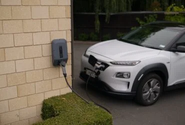 black car parked beside brown brick wall